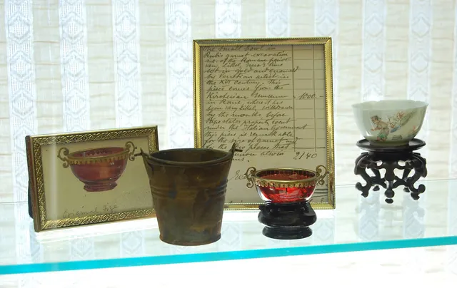 Alembic I: window case display with ruby cup, documentation, and “ironized” pail