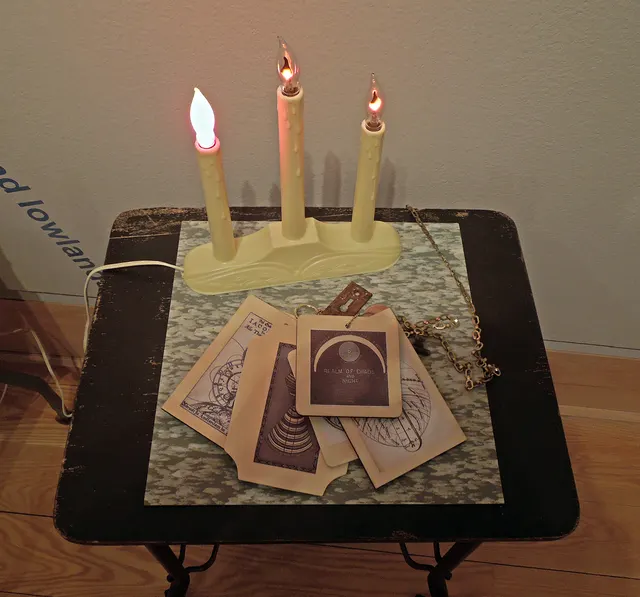 Cosmogony 2.0: cart detail with wooden cosmogony "books" and animated candles