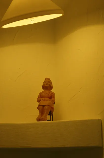 Mneme XXVII: Dolhuis [Madhouse]: detail: one of four elements in the upper corners of the cell; here an antique figure in a tiny chair