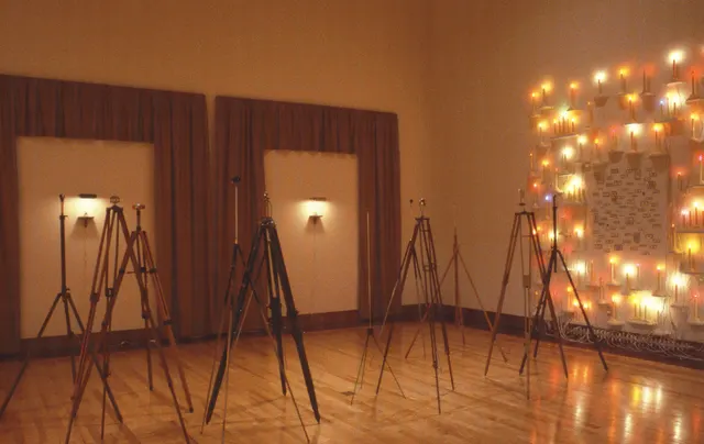 Surveying Desire II: Prospect & Refuge: gallery with tripods bearing viewing devices, votive walls of candles with personal ads