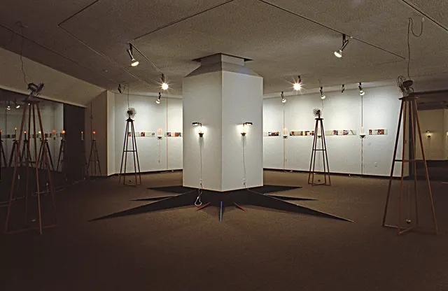 Surveying Desire X: Quest: compass rose on column with lines cast onto walls, and illuminated figures in domes