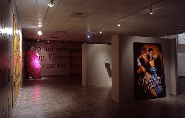 Surveying Desire XII: Fictions: Ouija board, rabbit's foot, green telephone, giant romance novel, suspended panel at right